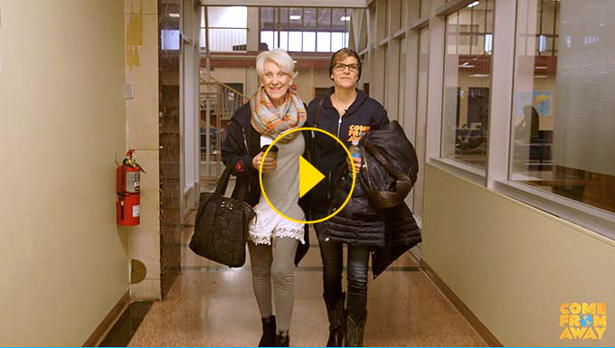 Thumbnail image of Beverley Bass and Jenn Colella walking through hallway of building in Gander
